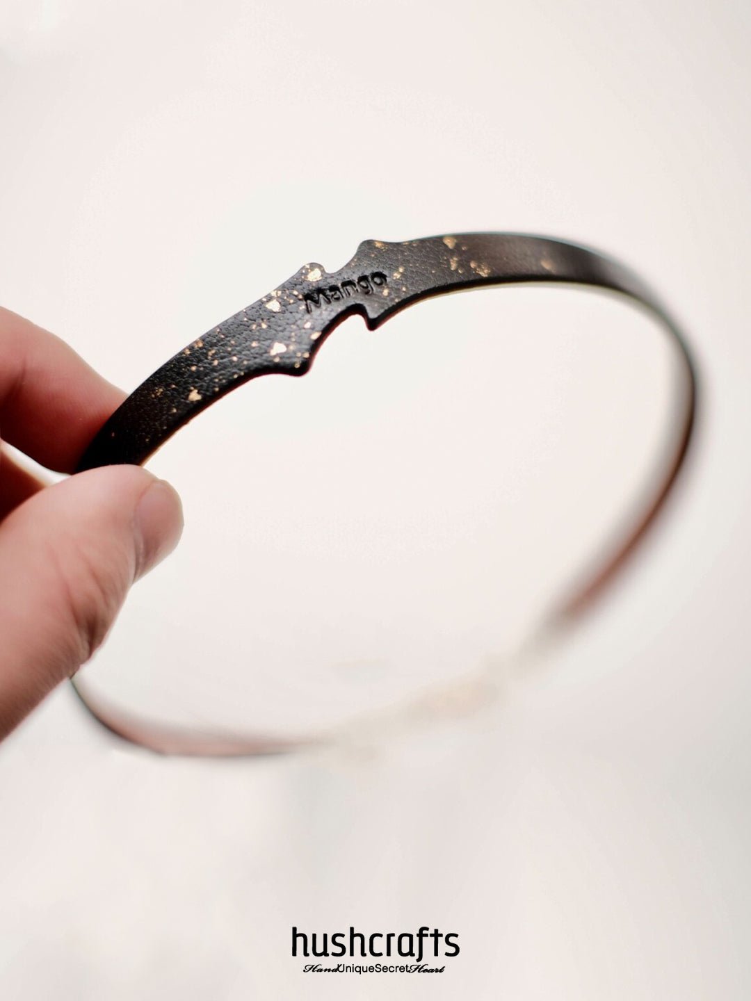Elegant black day collar choker with gold foil texture and bell dangle – HushCrafts signature minimalist piece in goatskin leather.