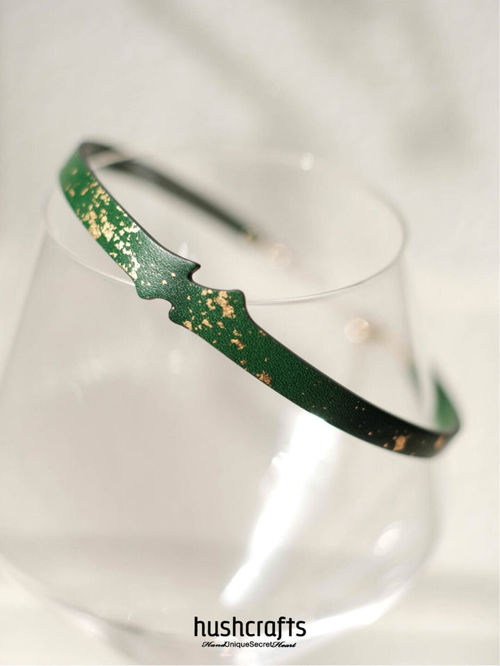 Refined green leather choker with shimmering gold flakes and a mini bell – HushCrafts day collar design with elegant adjustability.