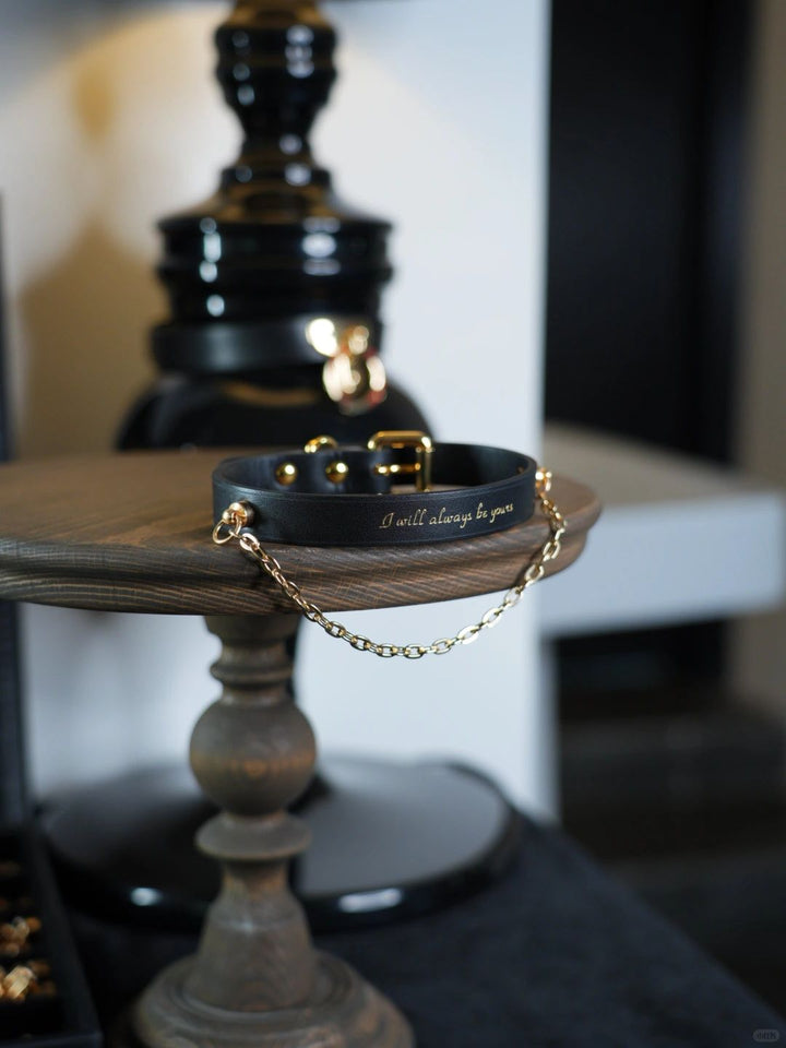 HushCrafts women's leather collar with BDSM chains, designed for both style and submission, featuring elegant gold accents and an engraved message for a personal touch.