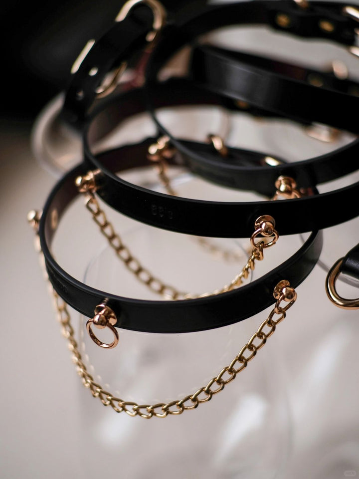 HushCrafts black leather collars featuring gold-tone O-rings and chains for a bold, stylish look. Perfect for everyday wear or BDSM accessories.