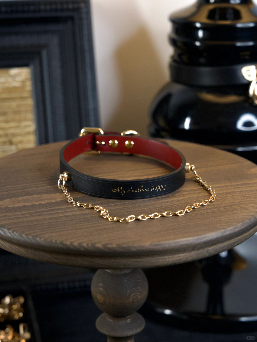 HushCrafts black leather submissive collar with gold chain, designed for elegant restraint and symbolic commitment.
