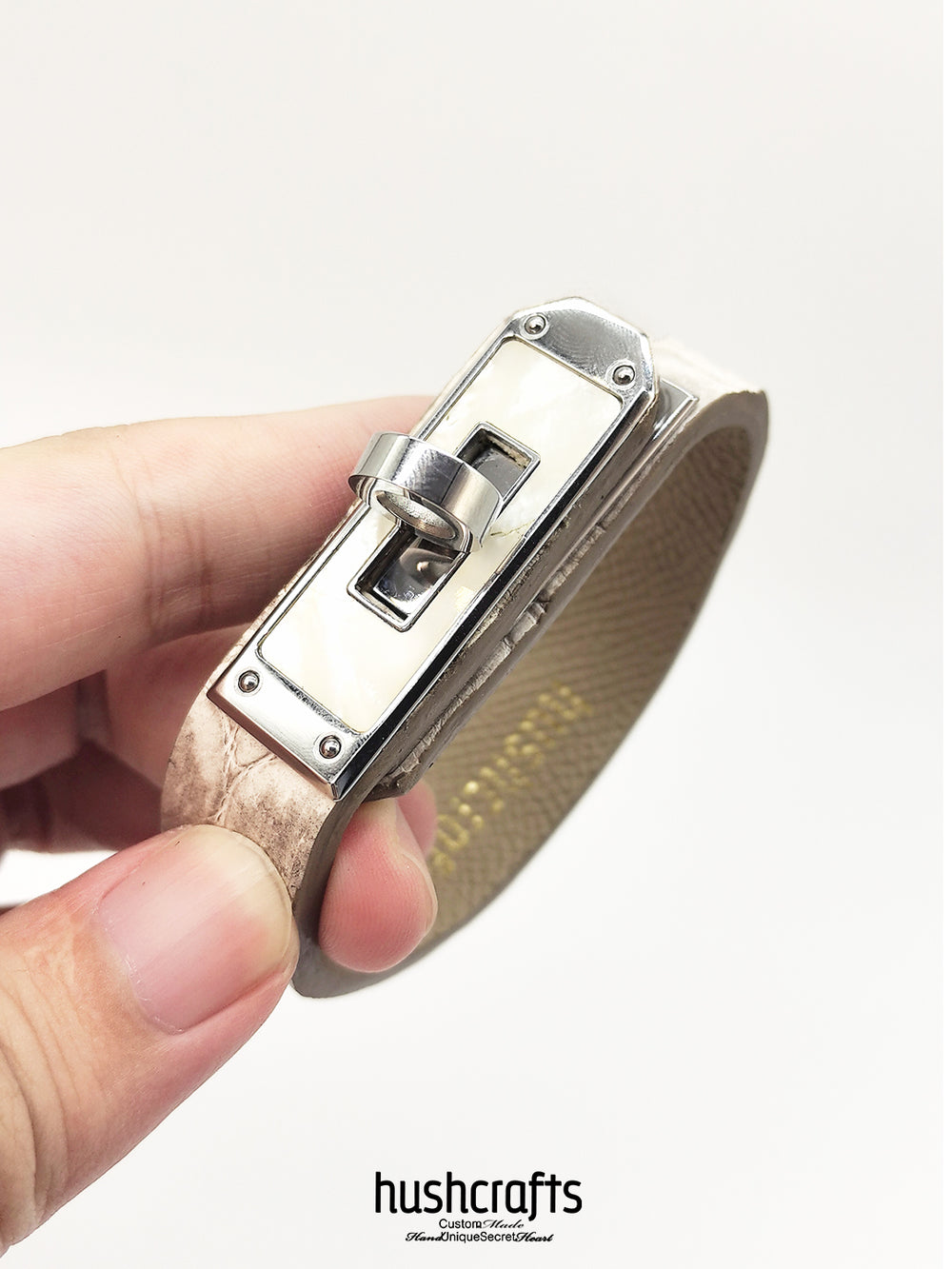 Himalaya Leather Bracelet held by a hand with 'hushcrafts' branding on a white background