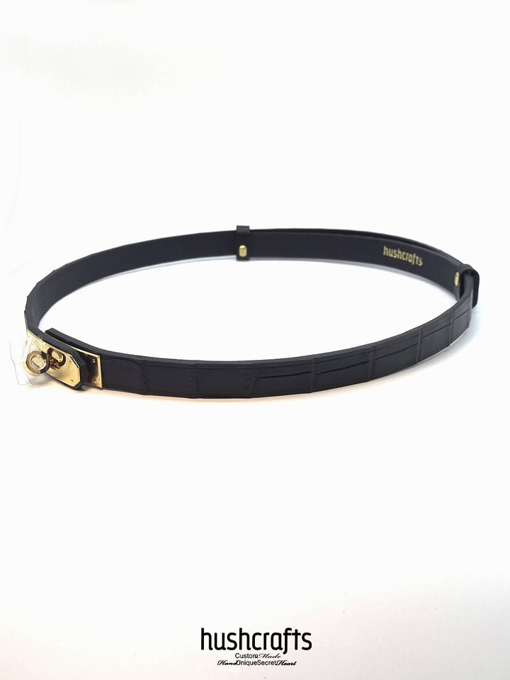 Black belt with gold buckle on a white background, featuring the brand 'hushcrafts'.