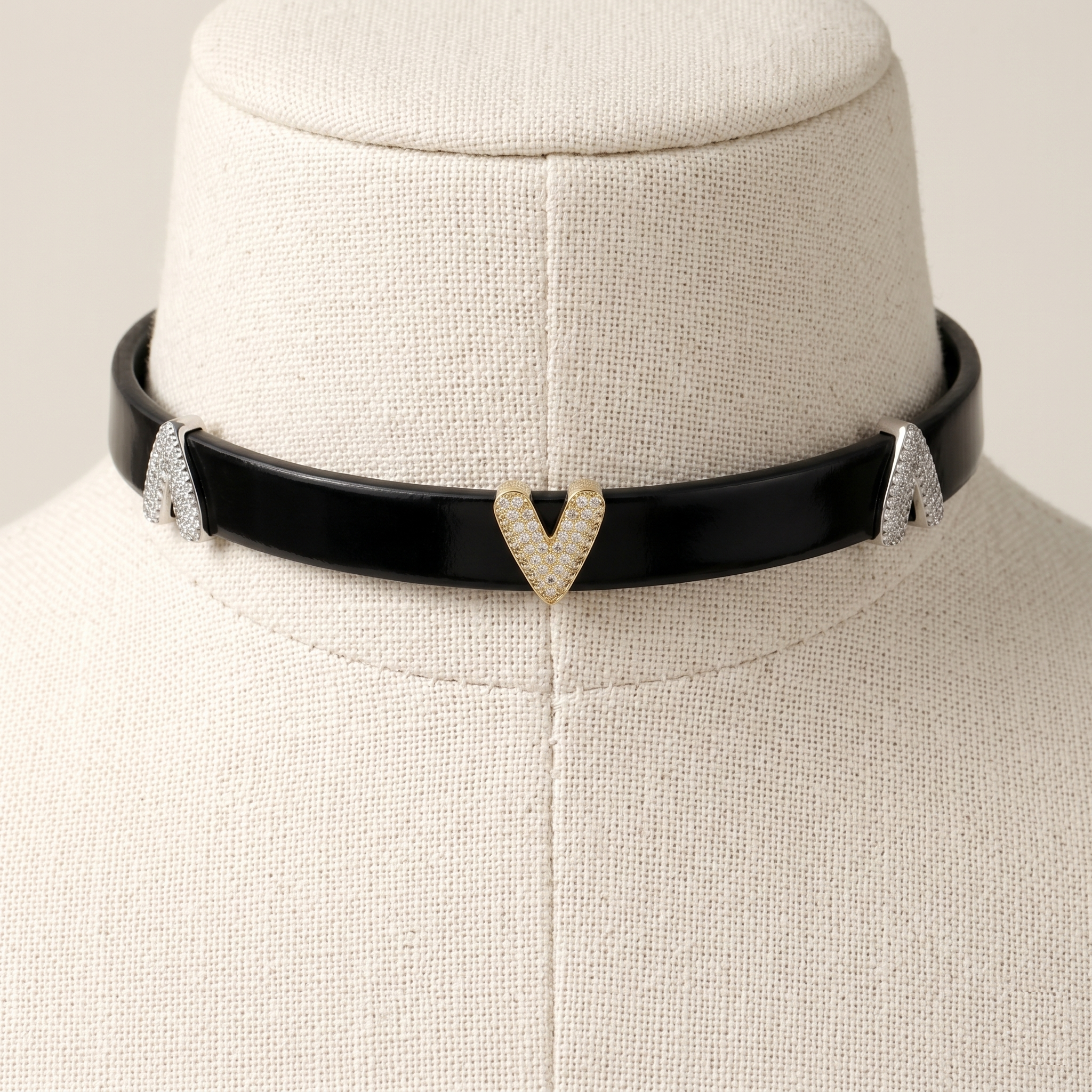 Black choker necklace with heart-shaped pendant on a mannequin bust.