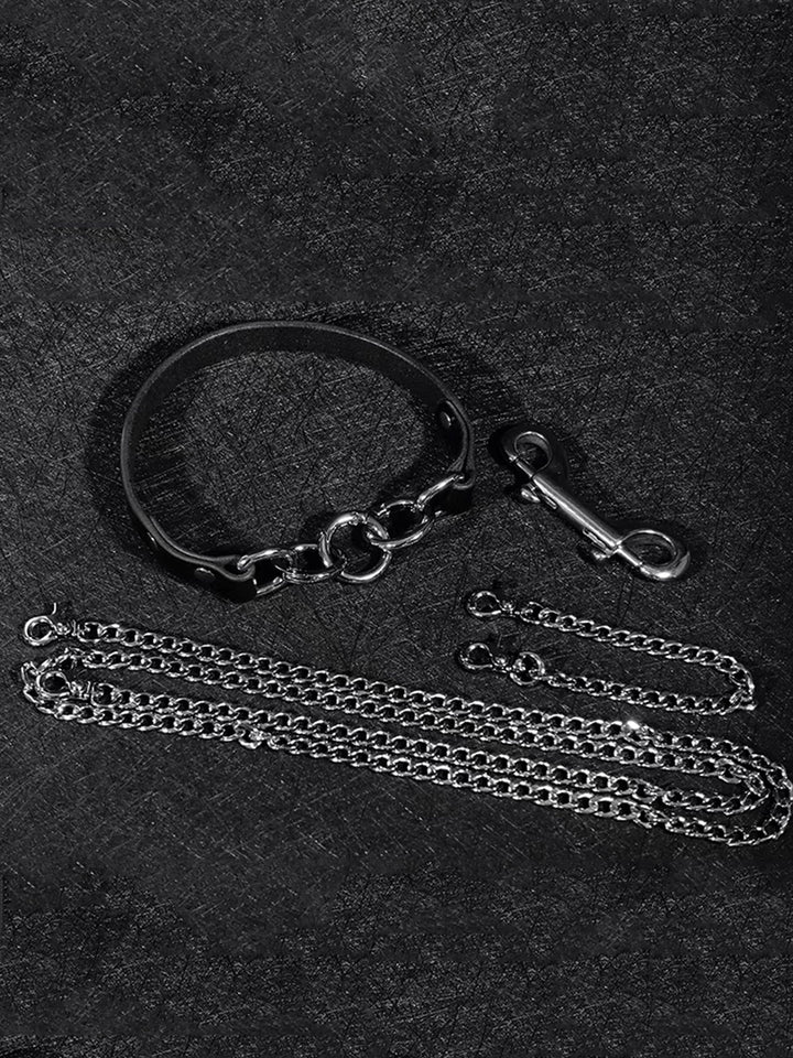 A black collar with a silver O-ring, accompanied by multiple chains and hooks for bondage play, showcasing a sleek, powerful design suitable for BDSM enthusiasts.