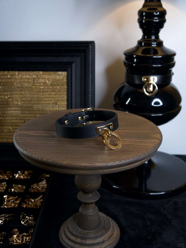 Handmade black leather collar necklace for women with gold hardware and BDSM-inspired design. Perfect handcrafted accessory to add an edgy and bold statement to your outfit. Hover Image