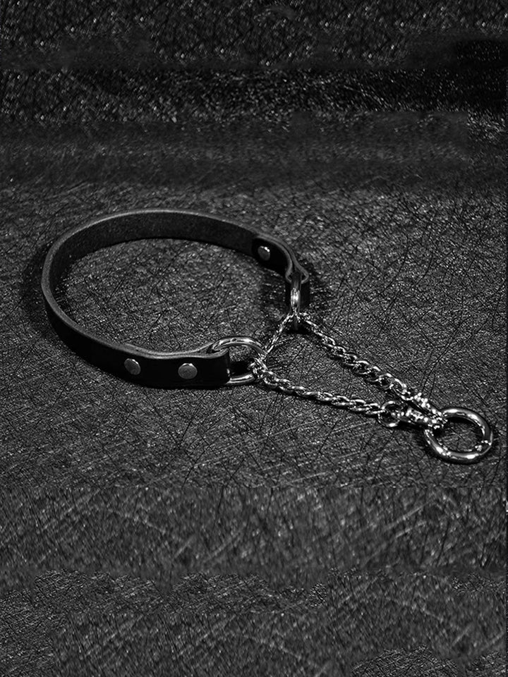 A black leather collar featuring an O-ring and dual silver chains, designed for a sleek and elegant bondage aesthetic, perfect for BDSM accessories.