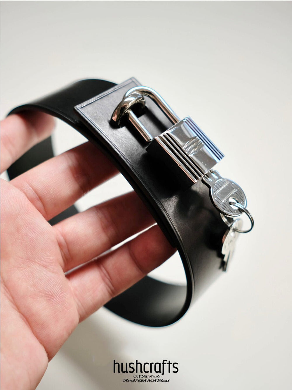 Close-up of the Silent Vow day collar showing smooth vegetable-tanned leather and polished padlock detail.